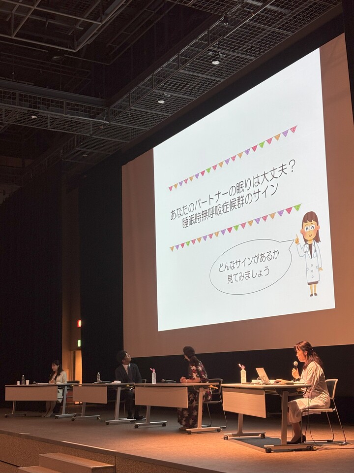 会場のスクリーンを見る登壇者